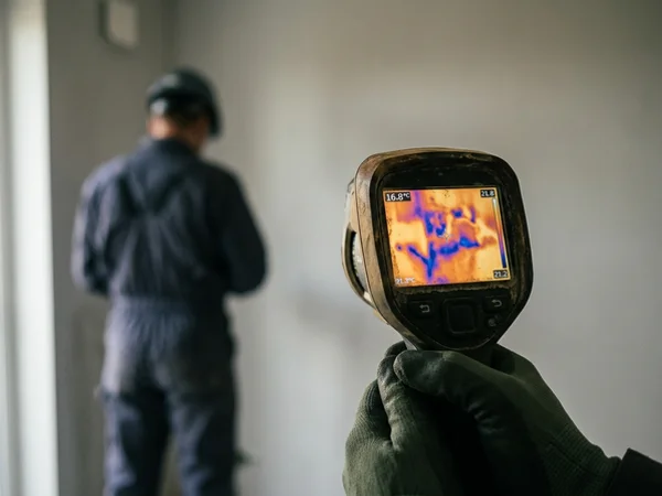 Thermal imaging screen showing a moisture pattern spreading across a wall