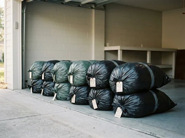 Sealed heavy-duty waste bags stacked for manifested transport