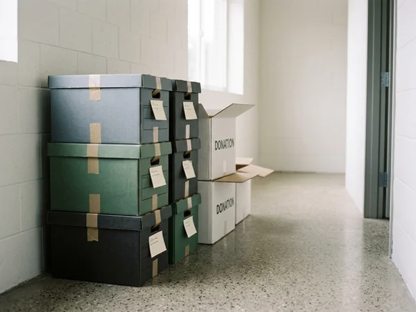 Labelled archive and donation boxes ready for pickup in a cleared hallway