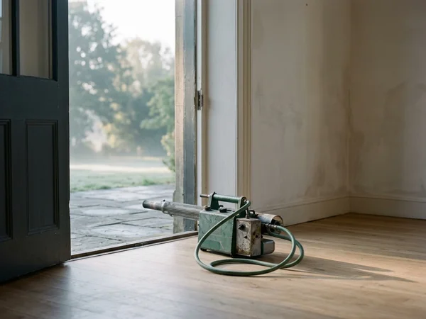 Thermal fogging equipment staged in the doorway of an empty room